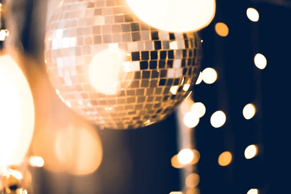 Beautiful disco ball with golden garland on black — Stock Photo