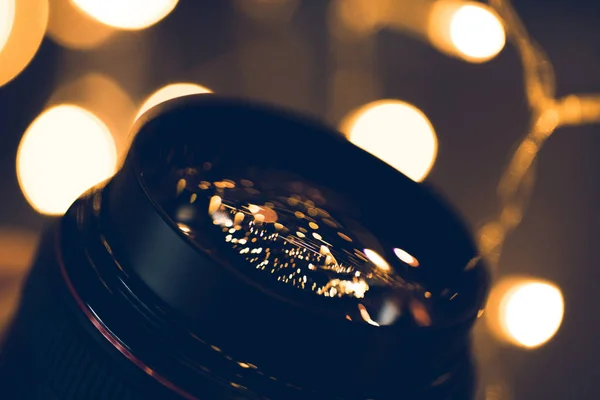 Close-up shot of christmas lights reflecting in glass of camera lens — Stock Photo