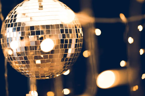 Glossy disco ball with beautiful garland on foreground — Stock Photo