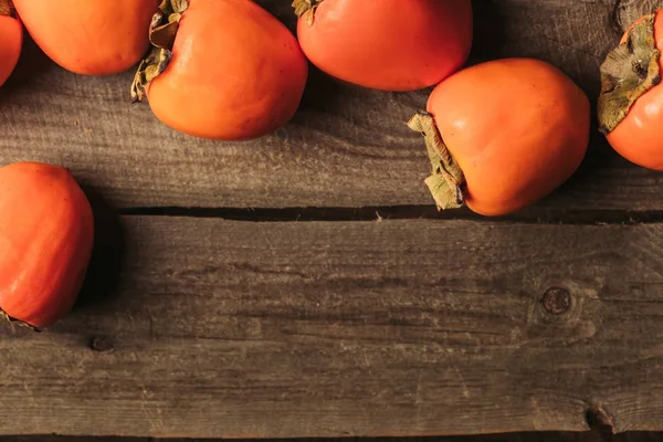 Top view of ripe persimmons on wooden surface — Stock Photo