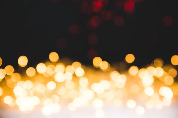 Goldene Bokeh-Lichter auf dunklem Weihnachtshintergrund — Stockfoto