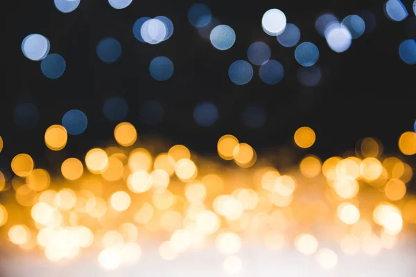 Christmas golden bokeh lights on dark background — Stock Photo