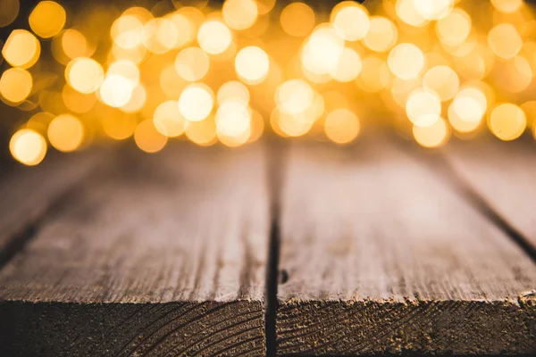 Lumières floues festives sur la surface en bois, fond de Noël — Photo de stock