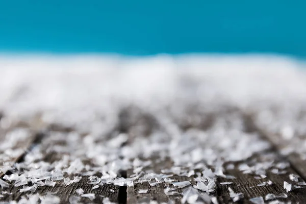 Зимний фон с размытым снегом на деревянной поверхности — стоковое фото