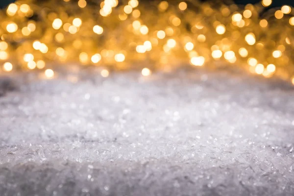Christmas winter background with snow and shiny blurred lights — Stock Photo