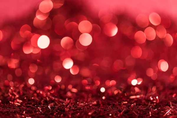 Christmas background with red shiny confetti with bokeh — Stock Photo