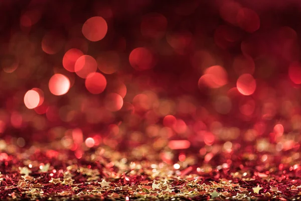 Christmas background with red shiny confetti stars — Stock Photo