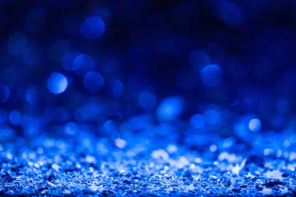 Christmas background with blue blurred shiny confetti stars — Stock Photo