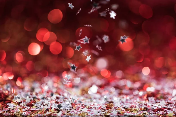 Christmas background with falling red shiny confetti stars — Stock Photo