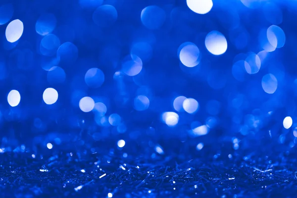 Christmas blue blurred shiny confetti with bokeh — Stock Photo