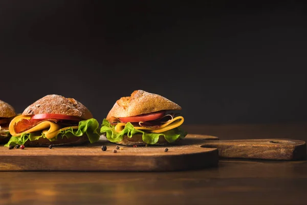 Sandwiches mit Käse und Gemüse auf Schneidebrett mit verstreuten Gewürzen — Stockfoto