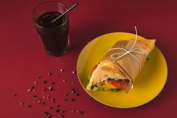 Overhead view of panini on plate and glass of cola on table — Stock Photo
