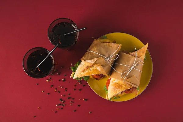 Vista superior de panini na placa e copos de cola na mesa — Fotografia de Stock