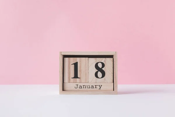 Vista de cerca del calendario de madera aislado en rosa - foto de stock
