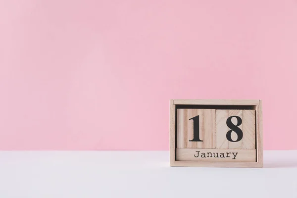 Close up view of wooden calendar isolated on pink — Stock Photo