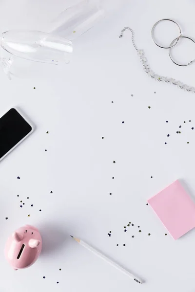 Flat lay with smartphone, pink piggy bank, sticky notes and jewelry isolated on white — Stock Photo