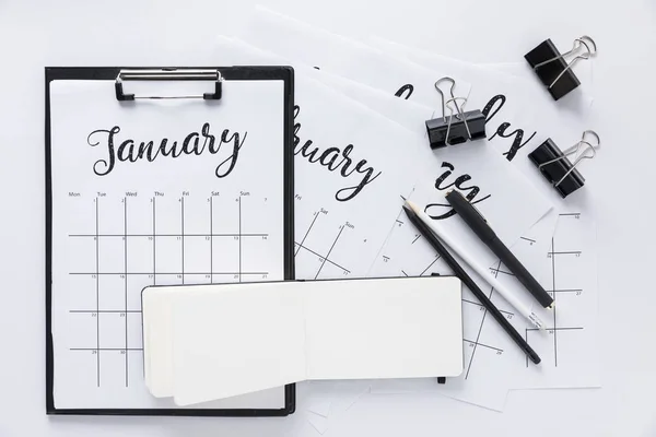 Top view of arrangement of office supplies and calendar isolated on white — Stock Photo