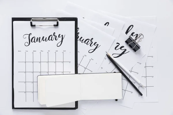 Top view of arrangement of office supplies and calendar isolated on white — Stock Photo