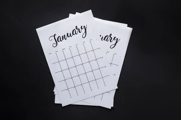 Vista superior de las partes dispuestas del calendario de papel aisladas en negro - foto de stock