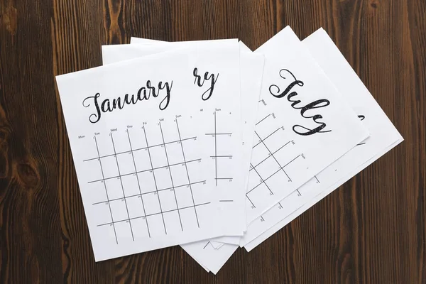 Vista superior da pilha de peças de calendário de papel na mesa de madeira — Fotografia de Stock