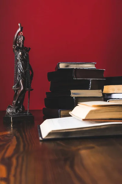 Opened juridical books with lady justice statue on wooden table, law concept — Stock Photo