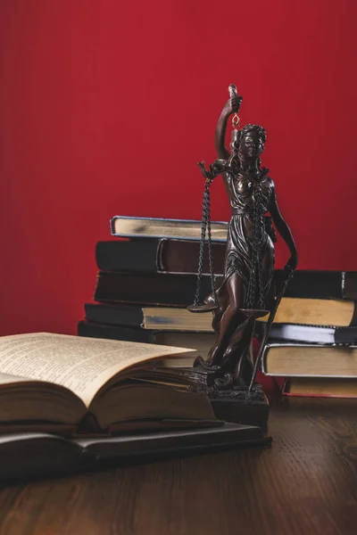 Открытые юридические книги со статуей леди правосудия на деревянном столе, юридическая концепция — стоковое фото