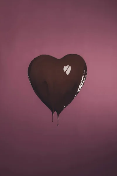 Doce em forma de coração com chocolate líquido isolado em rosa — Fotografia de Stock