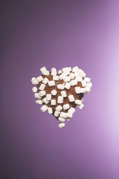 Chocolate heart shaped candy with marshmallow isolated on purple — Stock Photo