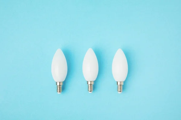 Top view of white lamps arranged in line isolated on blue — Stock Photo