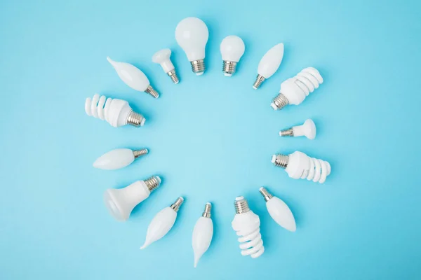 Top view of different white lamps arranged in circle isolated on blue — Stock Photo