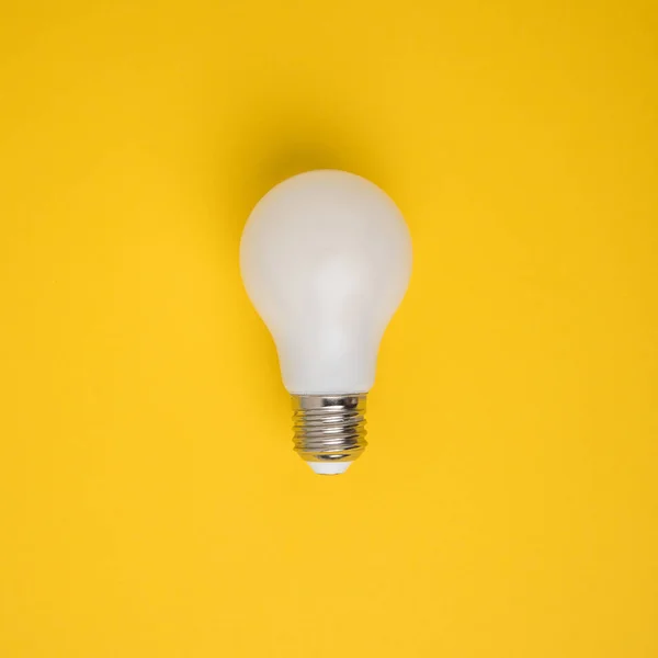 Close up view of white light bulb isolated on yellow — Stock Photo
