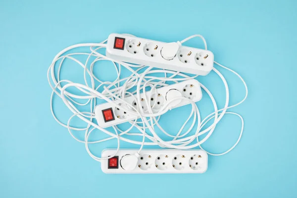 Top view of arrangement of extension cords isolated on blue — Stock Photo