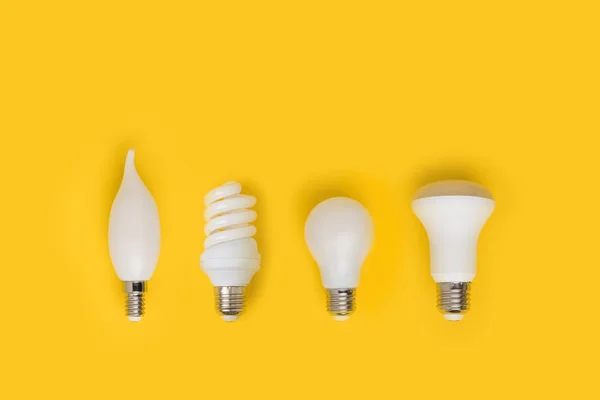 Vista superior del conjunto de diferentes lámparas blancas aisladas en amarillo - foto de stock