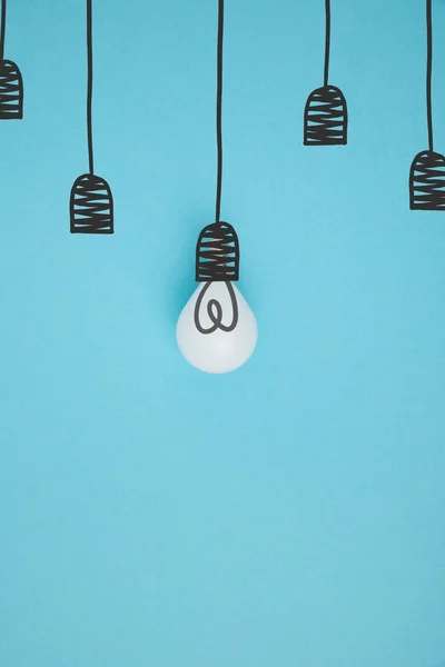 Top view of light bulb pretending hanging on lamp holder isolated on blue — Stock Photo