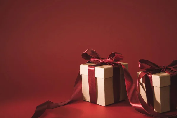 Vista de cerca de tres cajas de regalo decoradas con cintas en rojo - foto de stock