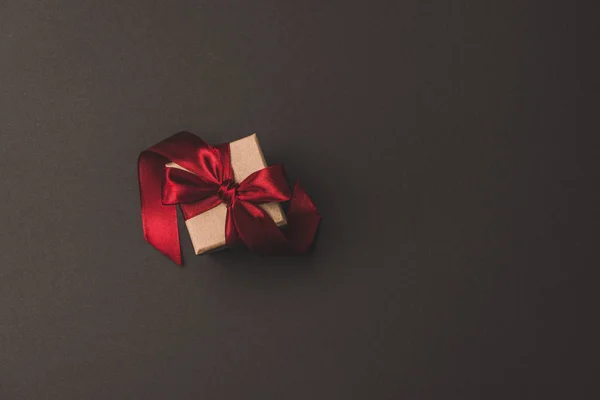 Top view of gift box with red ribbon isolated on dark surfae — Stock Photo