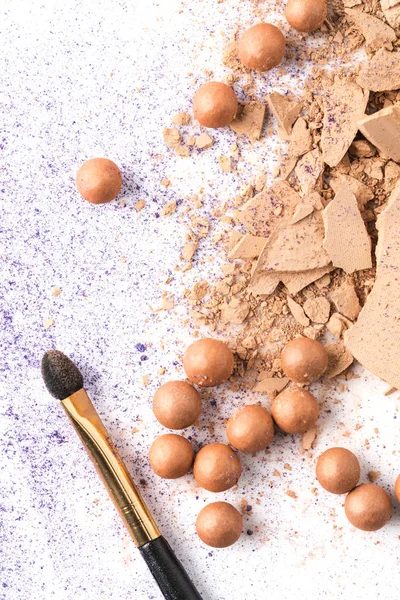 Top view of crushed cosmetic powder with brush on white table — Stock Photo