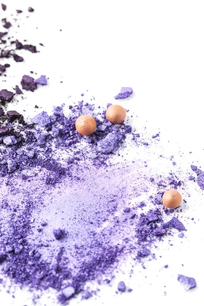 Purple cosmetic eye shadows spilled on surface isolated on white — Stock Photo