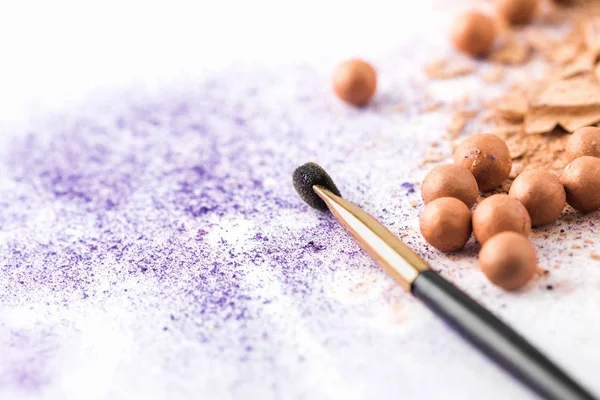 Purple and nude cosmetic powder with makeup brush on white surface — Stock Photo