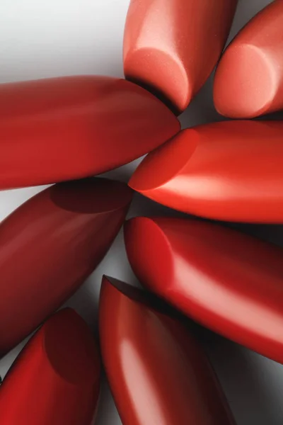 Nahaufnahme roter Lippenstifte in verschiedenen Schattierungen auf weißer Tischplatte — Stockfoto