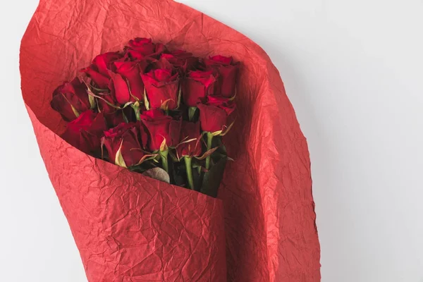 Vista superior del ramo de rosas en papel de regalo rojo aislado en blanco - foto de stock