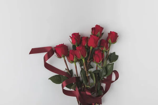 Вид зверху на красиві червоні троянди зі стрічкою ізольовані на білому, концепція дня Святого Валентина — стокове фото