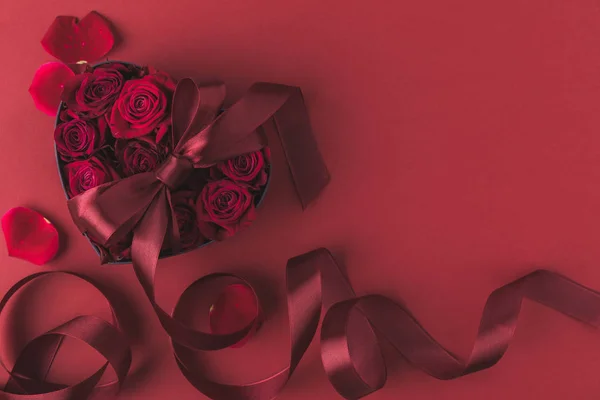 Vista superior de rosas en forma de corazón caja de regalo con cinta y pétalos aislados en rojo, San Valentín San Valentín concepto de vacaciones — Stock Photo