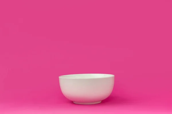 Крупным планом вид одной пустой белой миски, готовой к завтраку, изолированной на розовом фоне — стоковое фото