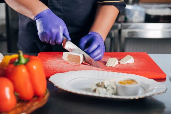 Tiro cortado de chef fatiar queijo para prato de queijo — Fotografia de Stock