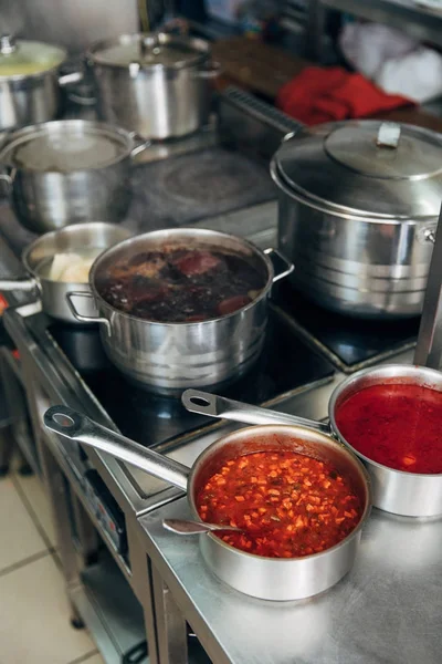 Varios alimentos en sartenes de salsa en la cocina del restaurante - foto de stock