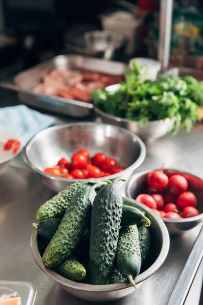 Миски с разнообразными свежими овощами на кухне ресторана — стоковое фото