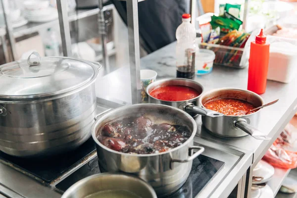 Delicious soup boiling in pan at restaurant kitchen — Stock Photo