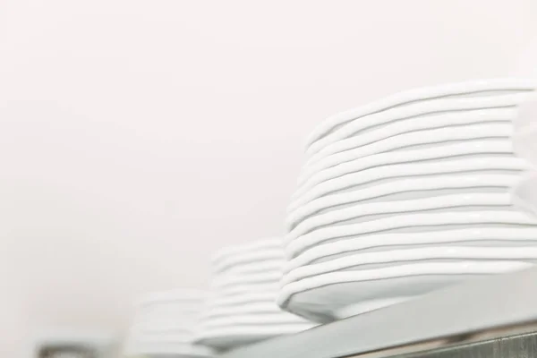 Close-up shot of stacks of clean tableware at restaurant on shelf — Stock Photo