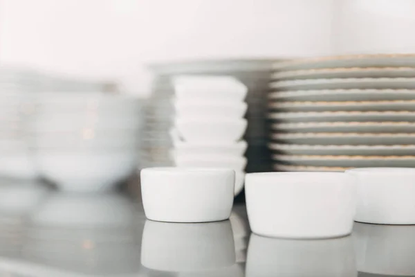 Close-up shot of stacks of various clean tableware at restaurant — Stock Photo